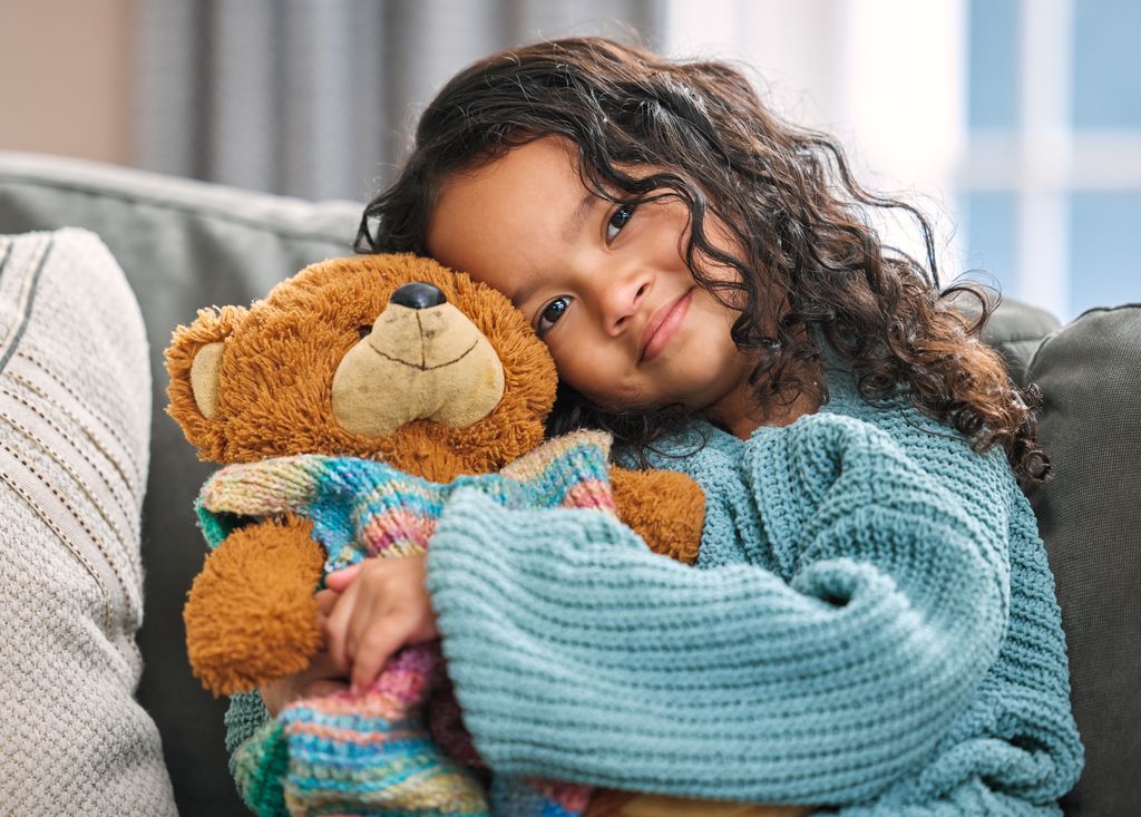 Niña abrazando un peluche de oso