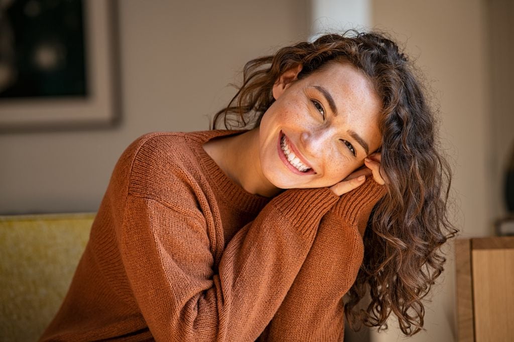 mujer relajada y feliz mirando a cámara