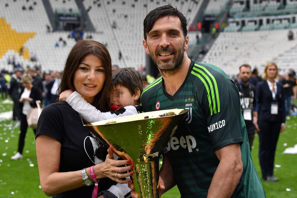 Gianluigi Buffon and Ilaria D Amico pose with their son at the foot of the grass after the goalkeeper won a trophy