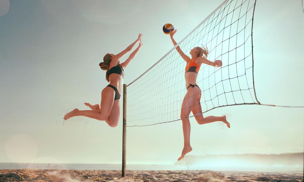 mujeres jugando voleibol en la playa