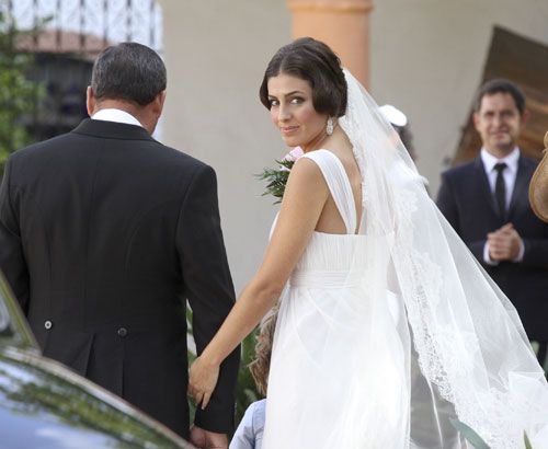 Elisabeth Garrido lució un diseño de Rosa Clará realizado en voile de seda natural con un cuerpo drapeado y de corte imperio, un velo de encaje y el pelo recogido en un moño muy andaluz