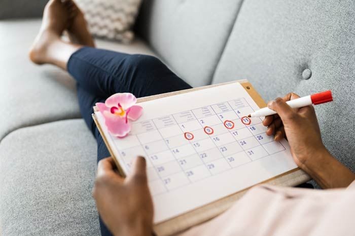 mujer apuntando en un calendario su ciclo menstrual