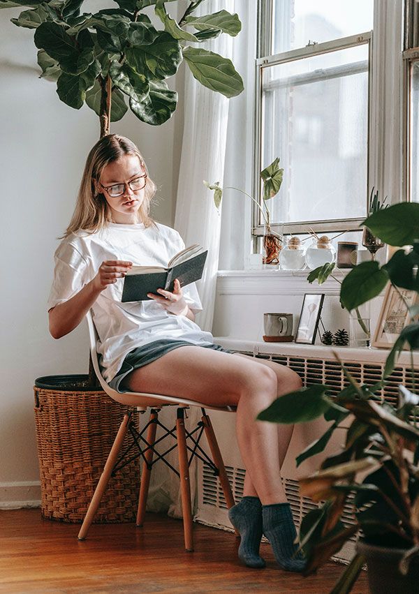 Mujer leyendo en casa junto al radiador
