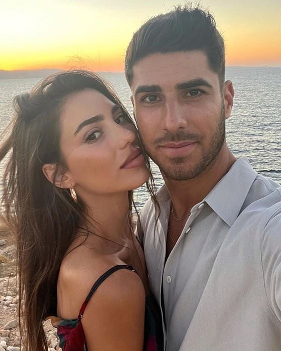 Marco Asensio y Sandra Garal abrazados en la playa  