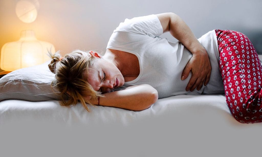 woman having stomach cramps and abdominal pain