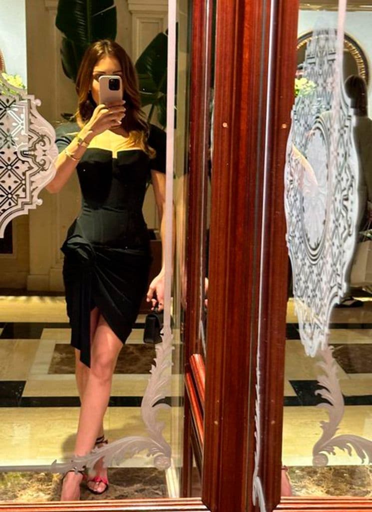 Hiba Abouk con vestido negro corto y sandalias de tacón