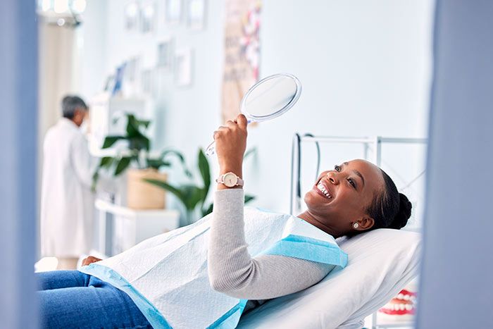 mujer en el dentista mirándose en un espejo