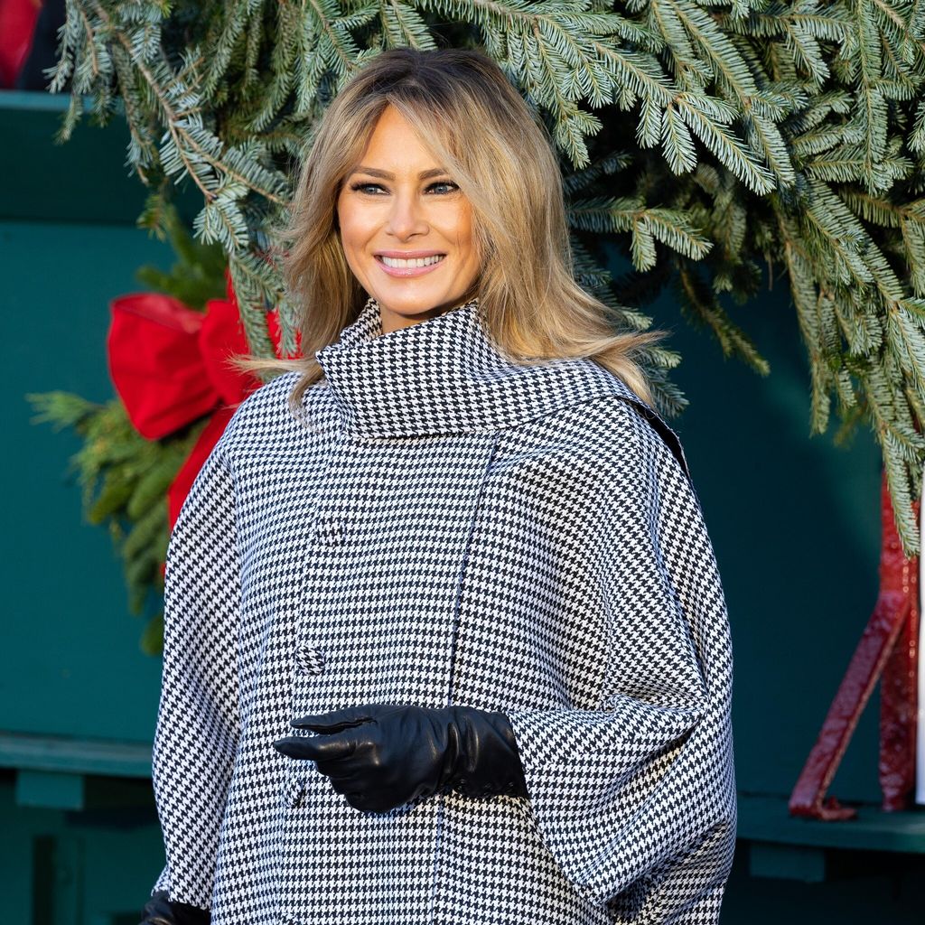 first lady melania trump posing with the carriage that is delivering the white house christmas tree 