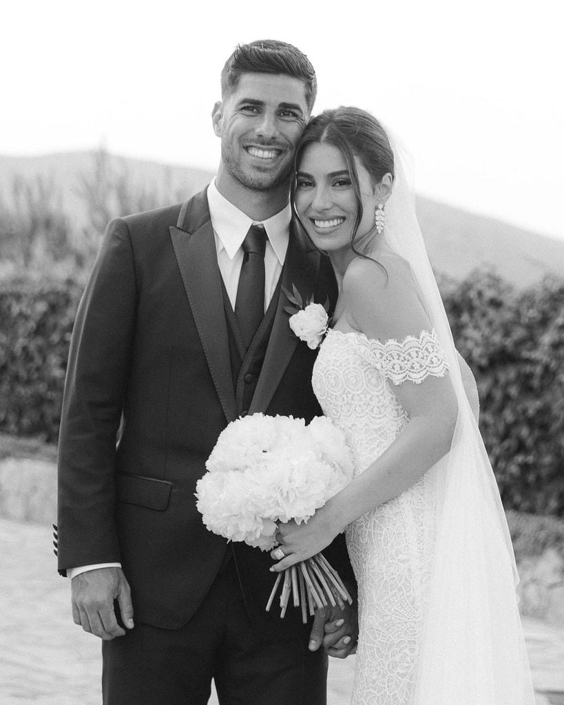 Marco Asensio y Sandra Garal posando juntos vestidos de novios