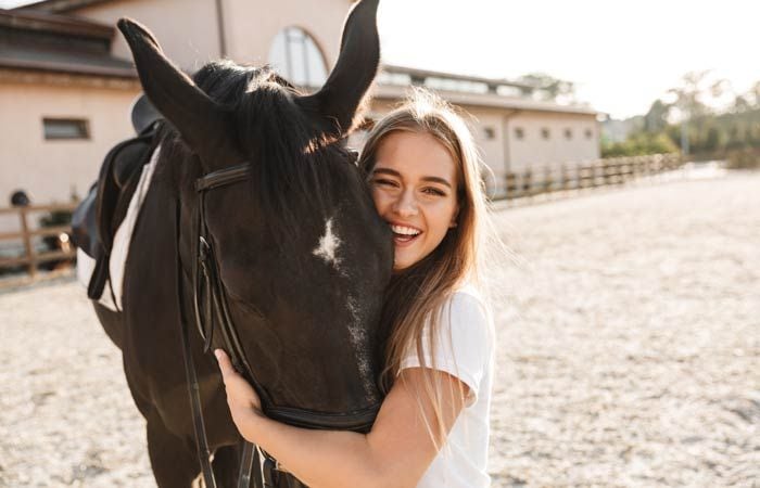 chica sonriendo con un caballo