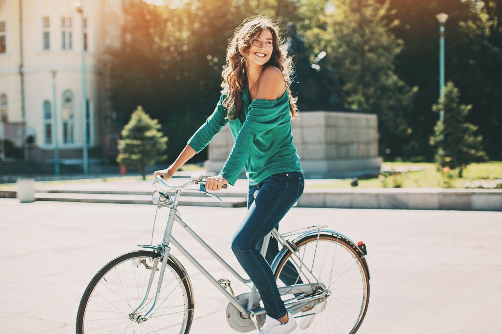 mujer sonriente montando en bicicleta