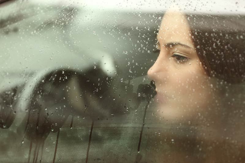 mujer lluvia ventana