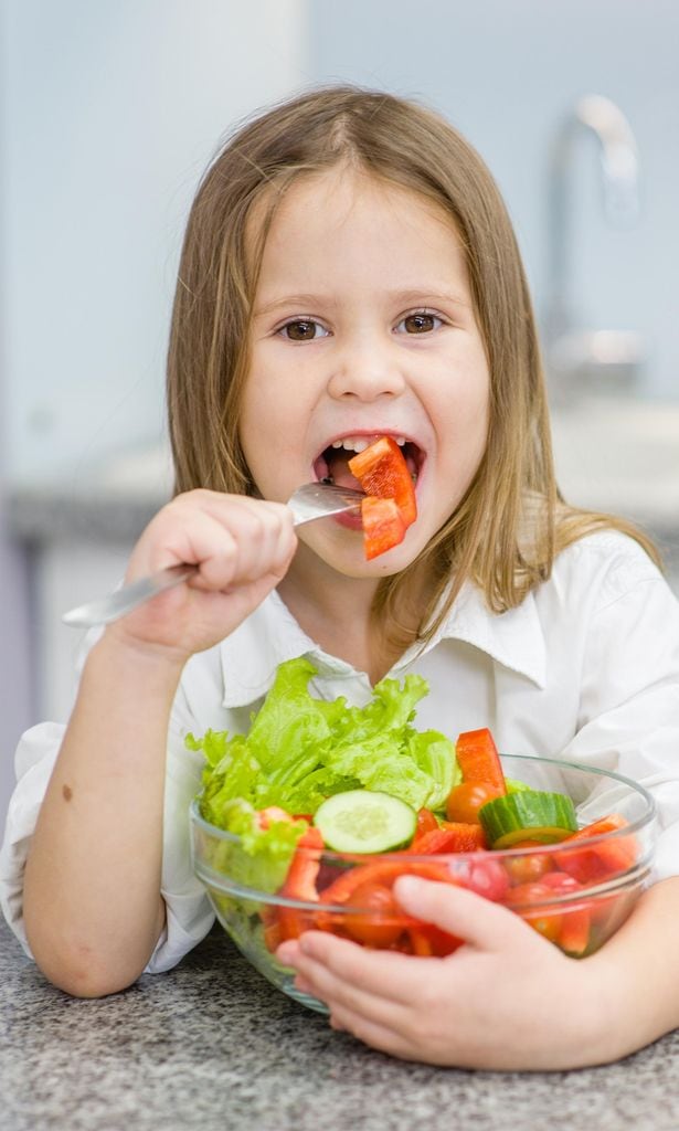 Niña comiendo verduras