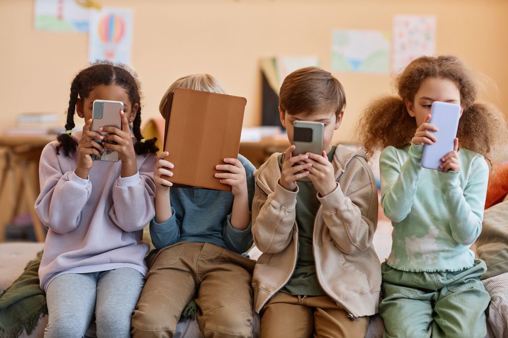 Grupo de niños mirando pantallas 