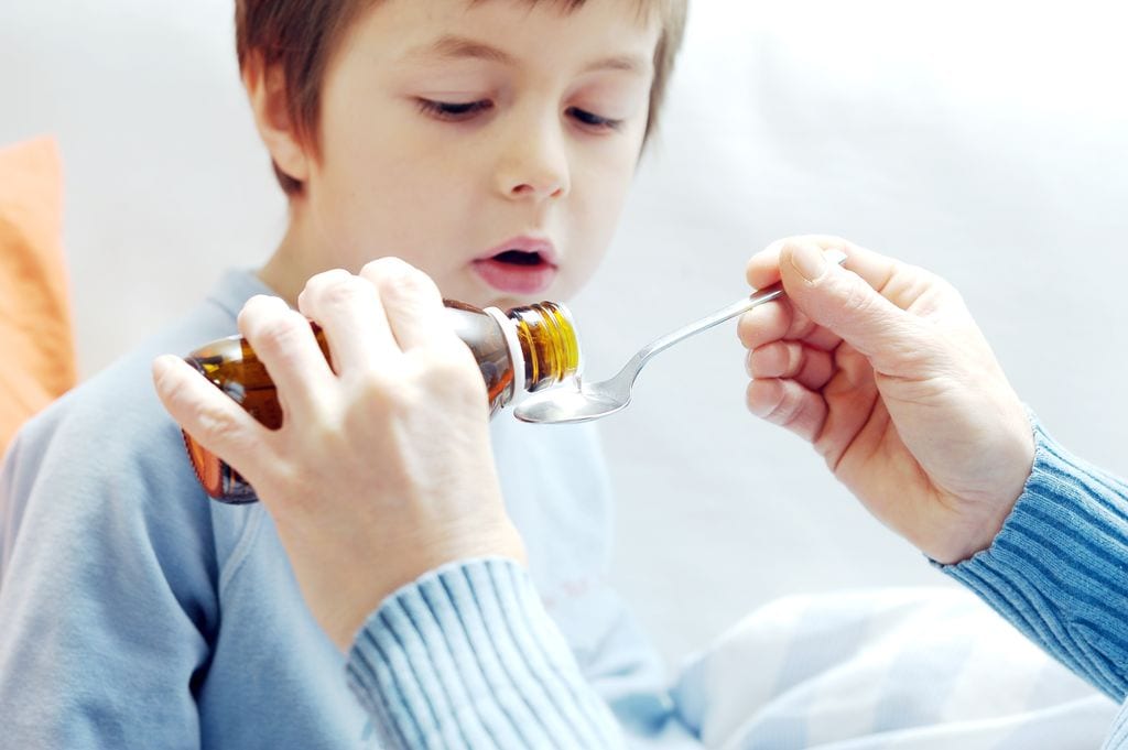 Niño tomando antibiótico en jarabe