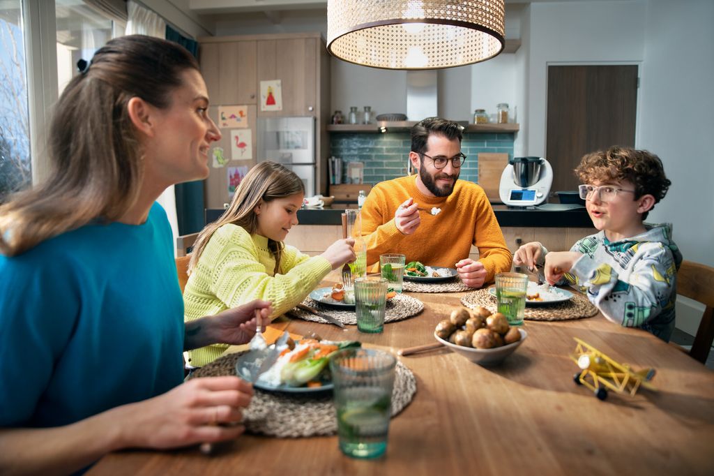 Familia en la mesa comiendo.