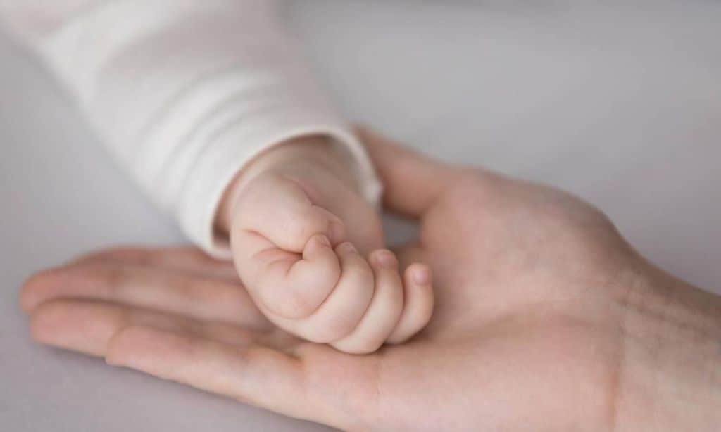 manita de beb sobre la mano de su mam 