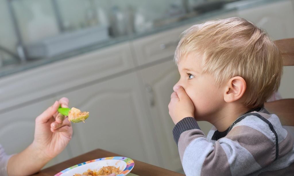 Niño tapándose la boca porque no quiere comer