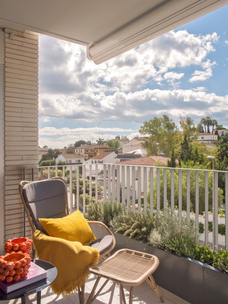 Terraza pequeña con sillón y reposapiés