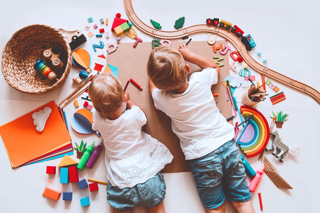 Niños jugando en el suelo con material Montessori