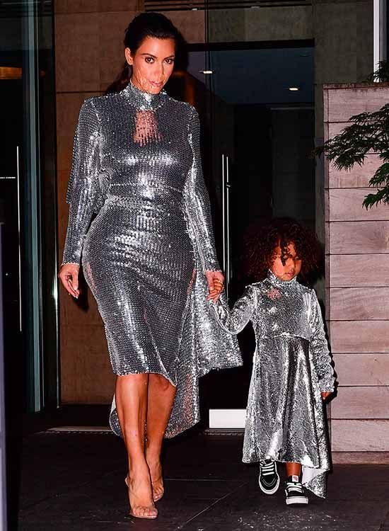 Madre e hija, Kim y North, eligieron el mismo vestido para acudir a ver a Kany West (marido y papá a la vez) al concierto que ofreció en el Madison Square Garden de Nueva York. Un diseño espejo pintado en plata metalizado confeccionado a base de cristales que componen mosaicos, de la firma Vetements. Kim optó por una ajustada versión, que combinó con unos salones transparentes de p.v.c; mientras que la pequeña North lucía un modelo más holgado, acorde a su temprana edad, que combinó con unas sneakers negras. Una nota casual que le otorgaba un acertado aire desenfadado.
