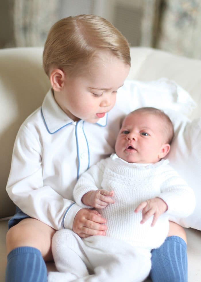 La princesa Charlotte, a las pocas semanas de su llegada al mundo, en el mullido regazo de su hermano mayor, el príncipe George, posando juntos en unión y buena compañía en la residencia familiar de Anmer Hall en Sandringham
