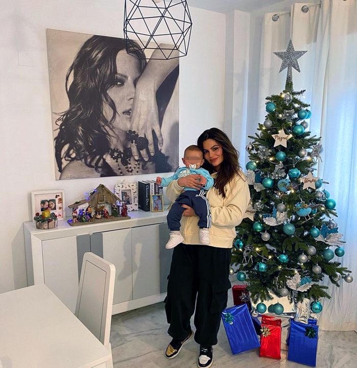 Marisa Jara posando con su hijo y la decoración navideña de su casa