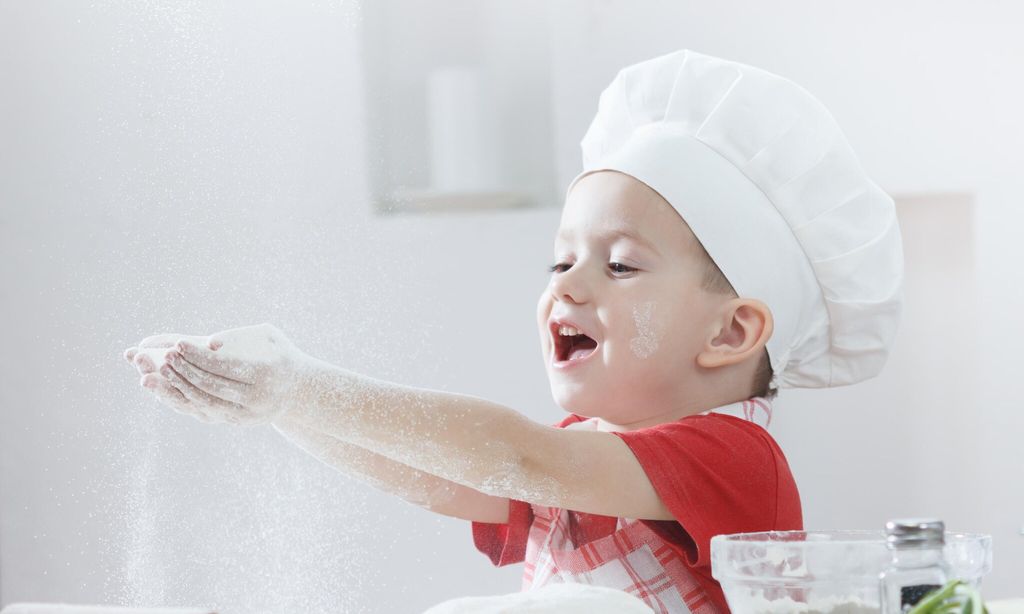 ni o con sombrero de cocinero haciendo pizza