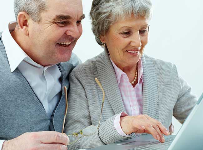 Pareja de jubilados mirando un ordenador