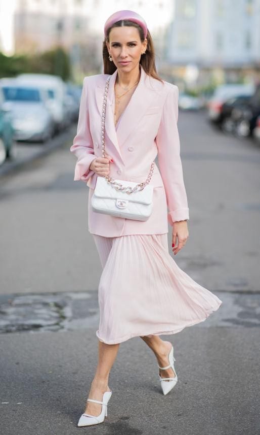 look de street style con falda midi plisada y mules blancos