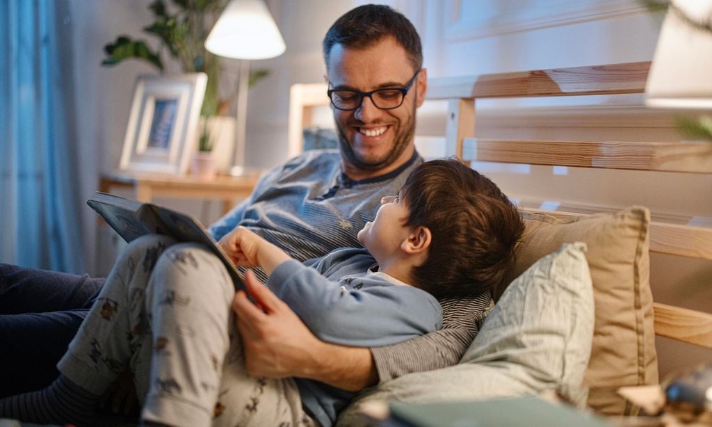 young father reading a bedtime story to his son