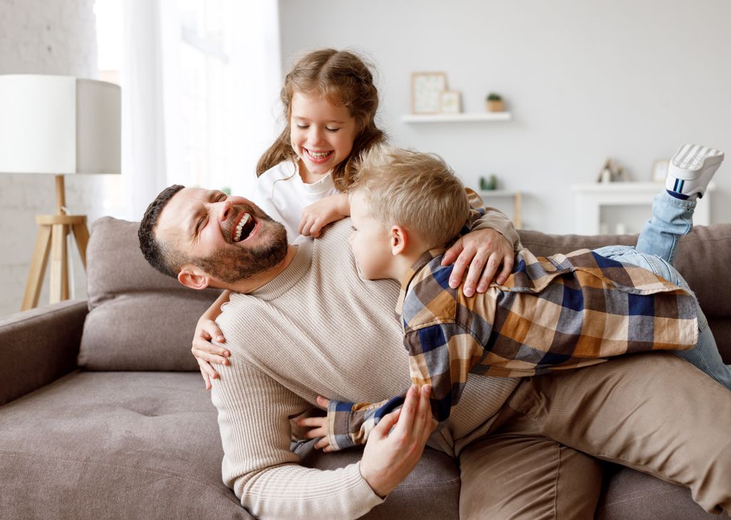 Padre riendo feliz con sus hijos