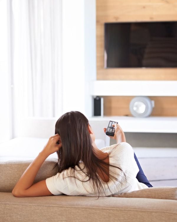 Mujer viendo la televisión en casa