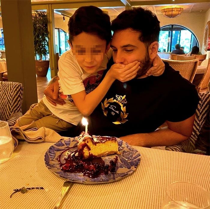 Omar Montes con su hijo soplando una vela
