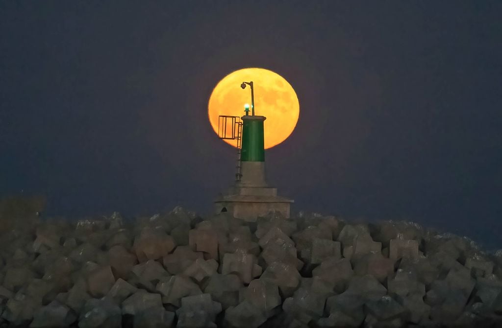 Superluna tras un faro marítimo