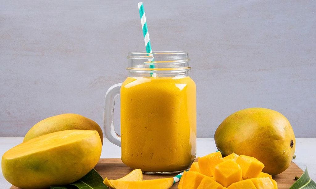batido de mango en una botella con rodajas de fruta de mango