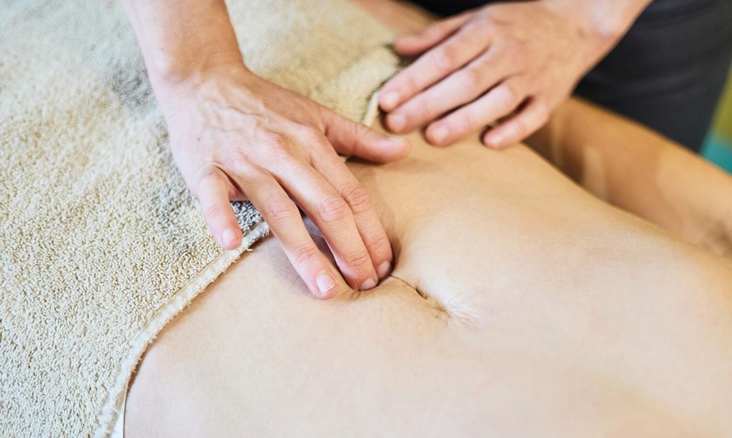 Osteopath performing a pelvic floor recovery massage on a patient