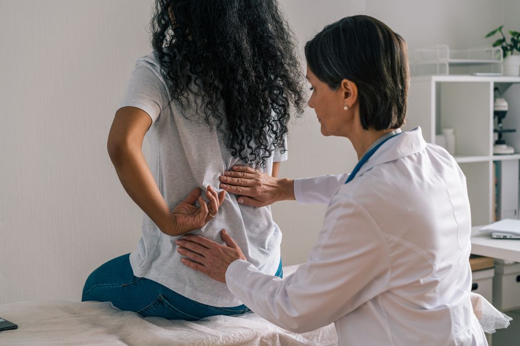 mujer en el médico con dolor de espalda