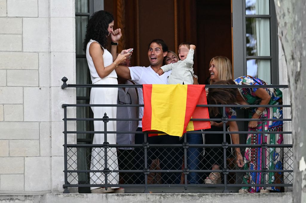 TOPSHOT - Spain's tennis player Rafael Nadal and his son Rafa Junior react on a balcony during the opening ceremony of the Paris 2024 Olympic Games in Paris on July 26, 2024. (Photo by Manan VATSYAYANA / AFP) (Photo by MANAN VATSYAYANA/AFP via Getty Images)