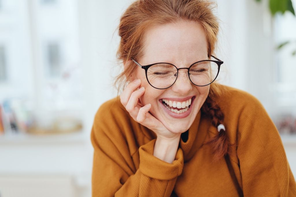 mujer pelirroja sonriente con gafas