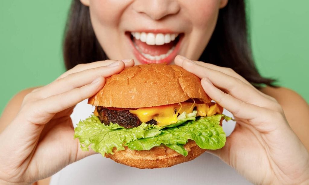 mujer comiendo hamburguesa