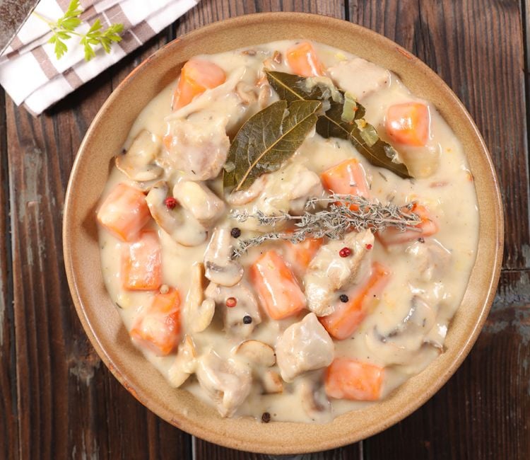 Plato de blanqueta terminada con laurel y otras hierbas aromáticas