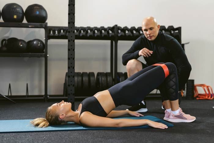 mujer haciendo ejercicio con su entrenador