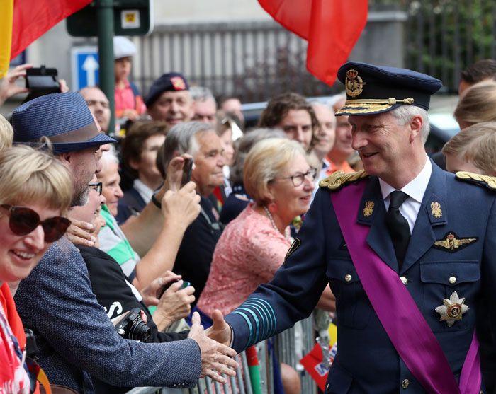 El rey Felipe de Bélgica saluda a las personas congregadas a las puertas de la iglesia.