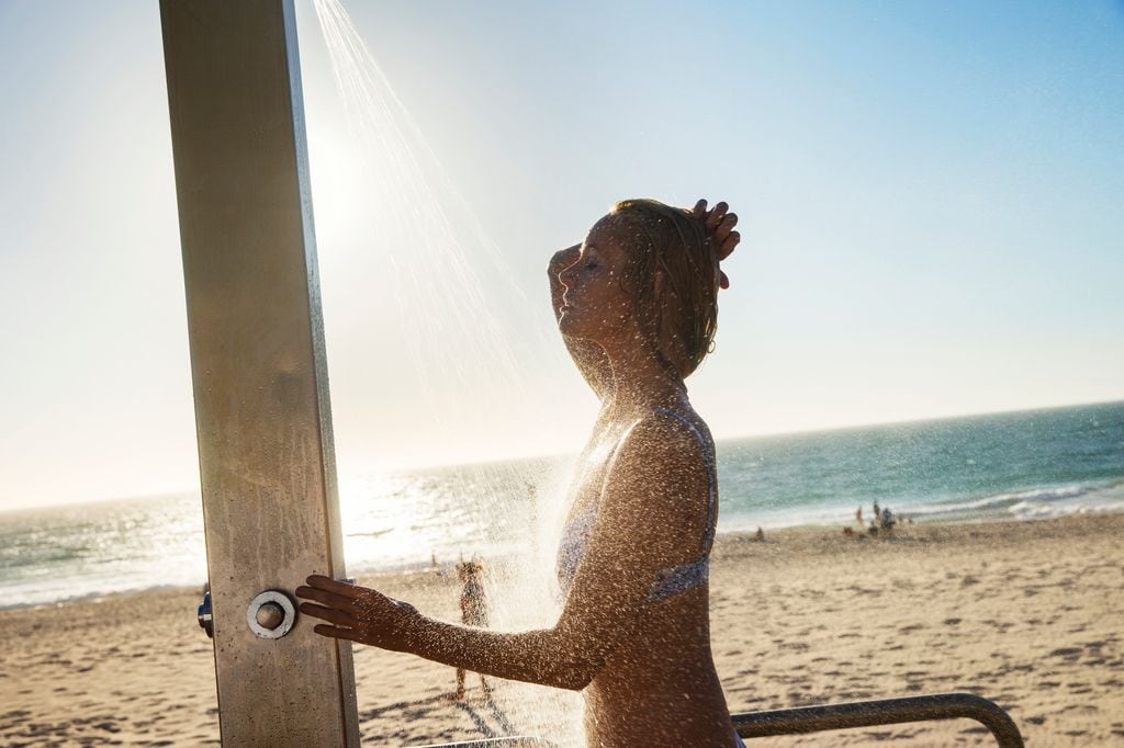 Mujer duchándose en la playa