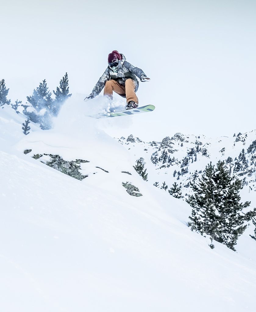 Persona haciendo salto de snowboard