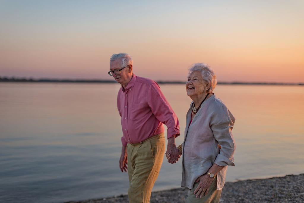 pareja de ancianos felices paseando por la playa