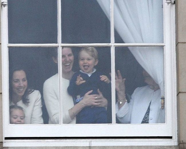 El príncipe George contempla el desfile Trooping the Colour o saludo a la bandera desde una de las ventanas del palacio de Buckingham en brazos de su niñera española, María Teresa Turrión
