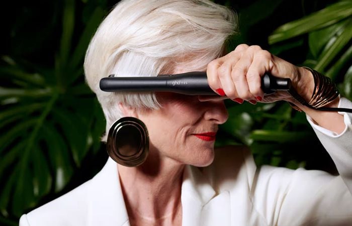 Mujer con pelo corto y blanco alisándose el cabello con ghd Mini