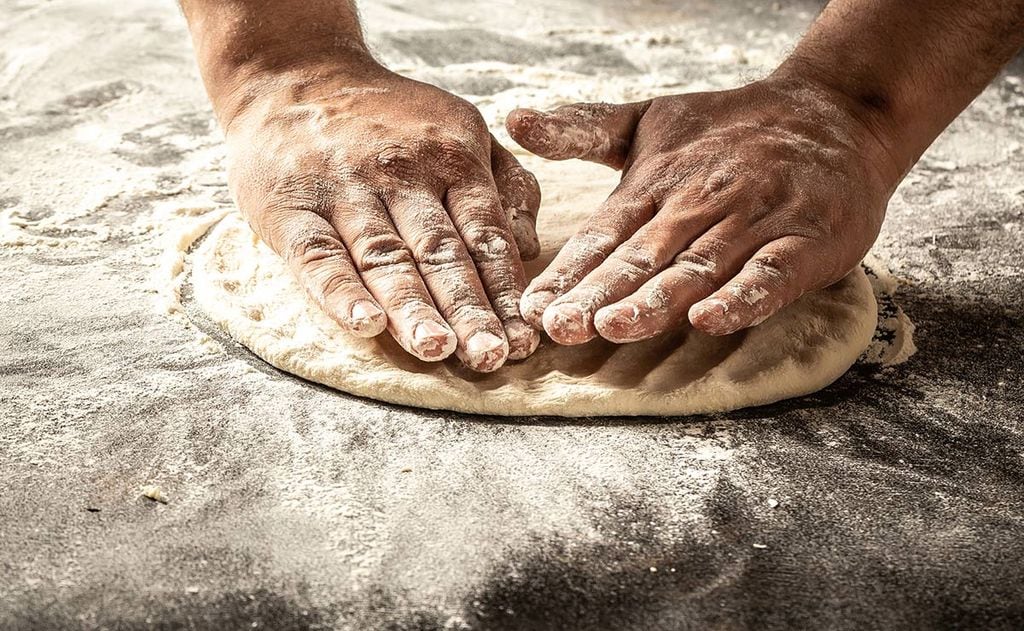 Para estirar la masa de pizza se pueden usar las manos y el rodillo.